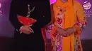 Kebaya yang dikenakan Iriana Jokowi ini serupa dengan yang pernah dikenakan sang menantu Erina Gudono. Kebaya oranye bermotif floral yang tak kalah cantik, dipadu kain batik sebagai rok, dan selendang oranye yang serasi. [Foto: YouTube Sekretariat Presiden]
