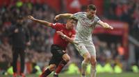 Duel Alexis Sanchez dan James Milner pada laga lanjutan Premier League yang berlangsung di stadion Old Trafford, Manchester, Minggu (24/2). Man United bermain imbang 0-0 kontra Liverpool. (AFP/Oli Scarff)