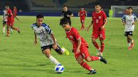 Pemain Timnas Indonesia U-16, Fandi Ahmad (kanan) menguasai bola dibayangi seorang pemain SKO Ragunan pada laga uji coba di Stadion Manahan, Solo, Rabu (12/6/2024) menjelang keikutsertaan Timnas Indonesia U-16 pada ajang Piala AFF U-16 2024. (Bola.com/Radifa Arsa)