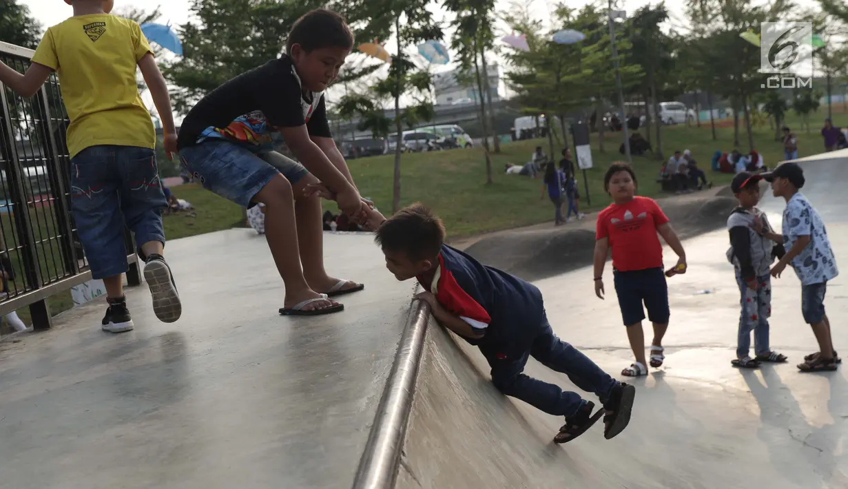 Beberapa orang anak bermain meluncur di area Skate Park RPTRA Kalijodo, Jakarta, Sabtu (15/6/2019). Menjelang sore hari, anak-anak berdatangan menghabiskan waktu dengan bermain di area RPTRA Kalijodo. (Liputan6.com/Helmi Fithriansyah)