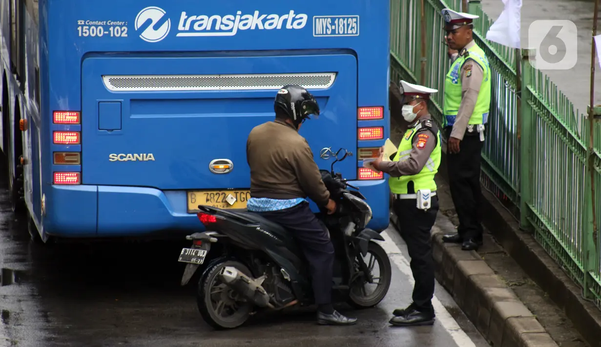 Petugas kepolisian lalu lintas merazia pengendara sepeda motor yang melintasi jalur bus Transjakarta di Jalan Sultan Agung, Manggarai, Jakarta, Kamis (6/2/2020). Meski melanggar, sebagian pengguna jalan secara sengaja masuk dan menggunakan jalur khusus bus tersebut. (Liputan6.com/Helmi Fithriansyah)