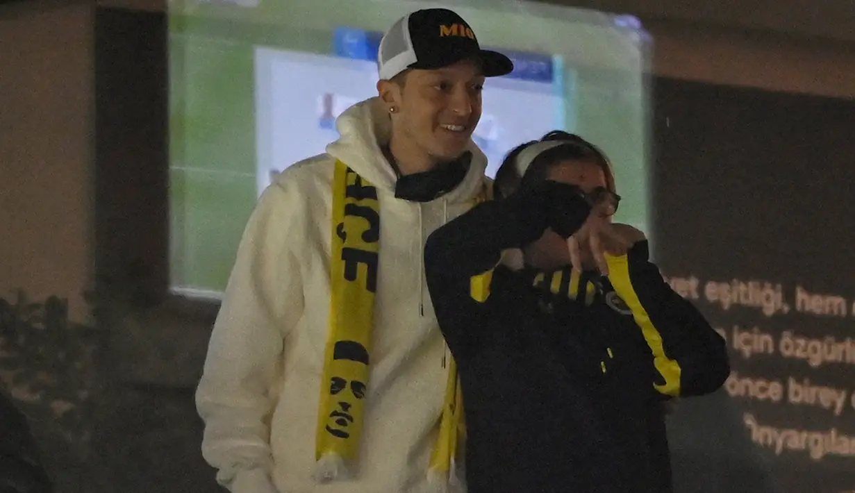 Pemain anyar Fenerbahce, Mesut Ozil melayani penggemar untuk berfoto saat menghadiri pertandingan timnya melawan Kaysersispor dalam lanjutan Turkish Super League di Istanbul, Senin (25/1/2021). (Foto: AFP/Ozan Kose)
