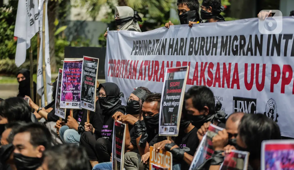 Pengunjukrasa dari Serikat Buruh Migran Indonesia membentangkan spanduk dan poster di Kementerian Ketenagakerjaan, Jakarta, Rabu (18/12/2019). Aksi  memperingati Hari Buruh Migran Internasional itu mendesak Negara bertanggung jawab atas perlindungan hak buruh migran. (Liputan6.com/Faizal Fanani)
