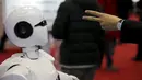 Pengunjung saat berinteraksi dengan KINGER pada Pameran Dunia Robot selama Konferensi Robot Dunia di Beijing, Cina,  (24/11). Selain pameran robot, Acara ini juga mengadakan kontes robot bagi para pelajar dan pemuda. (REUTERS/Jason Lee)