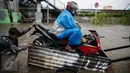 Pengendara sepeda motor memanfaatkan jasa gerobak untuk menyeberangi banjir di Jalan Gunung Sahari, Jakarta Pusat, Selasa (21/2). Hujan deras yang mengguyur sejak Selasa dini hari membuat sebagian wilayah di Jakarta banjir. (Liputan6.com/Faizal Fanani)