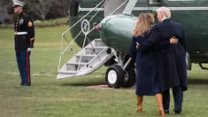 Presiden AS Donald Trump terlihat memegang ibu negara, Melania Trump yang hampir terjatuh saat berjalan menuju helikopter kepresidenan di halaman berumput Gedung Putih, Senin (19/3). Trump dan Melania hendak bertolak ke New Hempshire. (JIM WATSON/AFP)