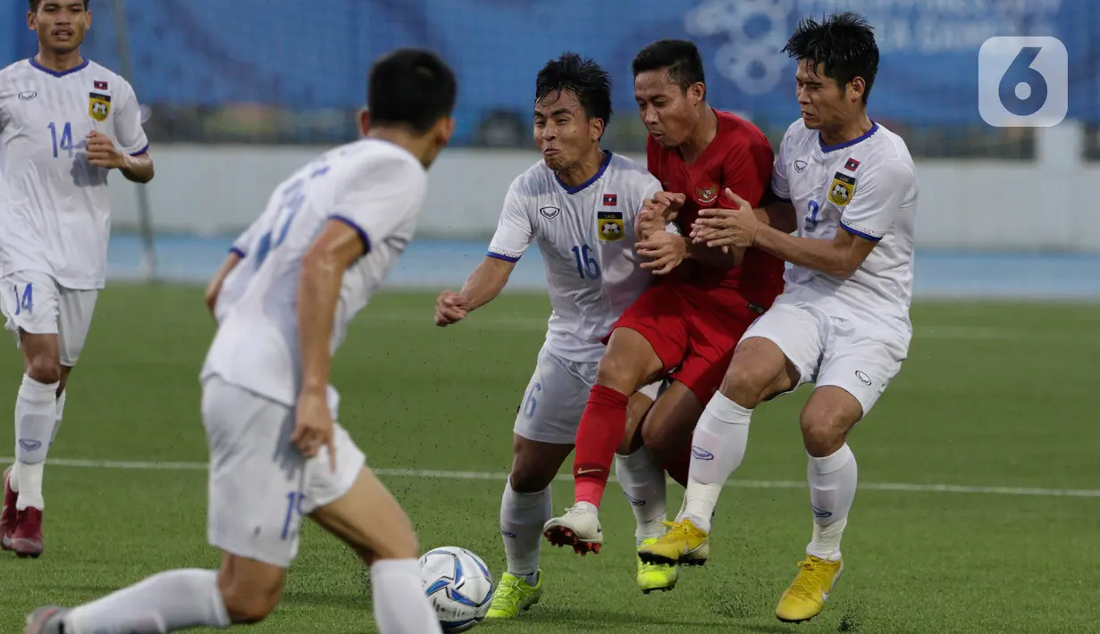 Gelandang Timnas Indonesia U-22, Evan Dimas, terjepit saat melawan Timnas Laos dalam pertandingan Grup B SEA Games 2019 di Stadion City of Imus Grandstand, Filipina, Kamis (5/12/2019). Timnas U-22 Indonesia berhasil melaju semifinal setelah mengalahkan Laos 4-0. (Bola.com/M Iqbal Ichsan)