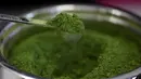 Sam Butarbutar mengambil sesendok matcha dari wadah sambil membuat minuman matcha di Third Culture, Berkeley, California, Amerika Serikat pada 15 Juli 2025. (Justin Sullivan/Getty Images North America/Getty Images via AFP)