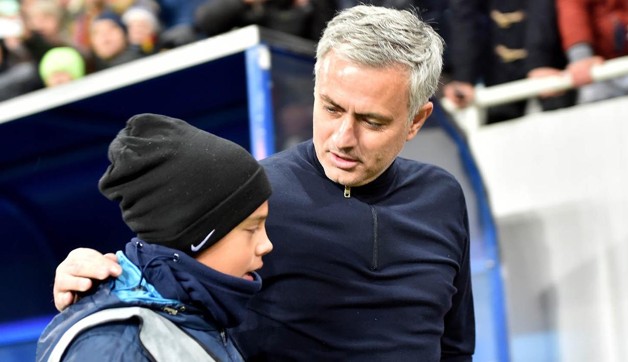 Manajer Manchester United, Jose Mourinho, menyempatkan diri untuk berbincang dengan sang anak saat jeda pertandingan. (AFP/Sergei Supinsky)