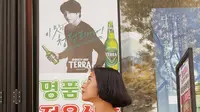 Yang ini, dia foto bareng poster Gong Yoo untuk iklan sebuah minuman. Ibu satu anak ini tampak serius melihat ketampanan aktor kesayangannya. (Foto: Instagram/ putrimarino)