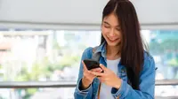 Ilustrasi seorang perempuan mengisi pulsa via smartphone. (marchmeena/depositphotos.com)