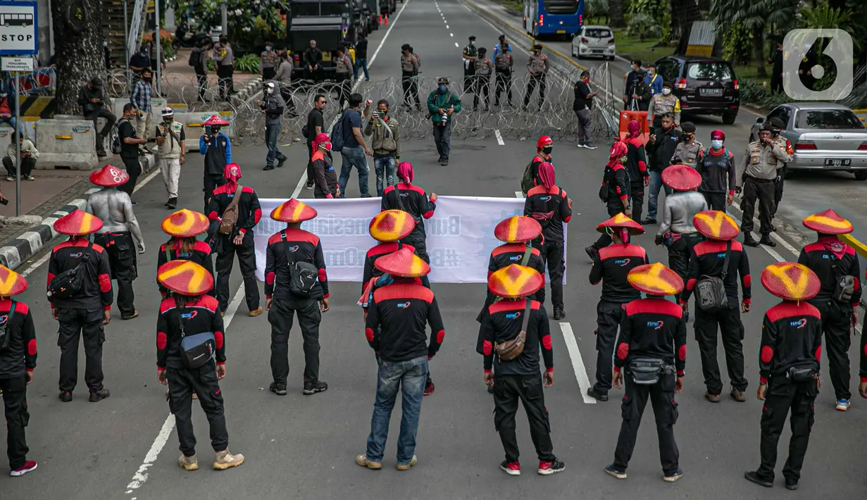 Massa aksi yang tergabung dalam Serikat Pekerja Indonesia (KSPI) membawa spanduk dan poster saat unjuk rasa di kawasan Patung Kuda, Jakarta, Rabu (16/12/2020). (Liputan6.com/Faizal Fanani)