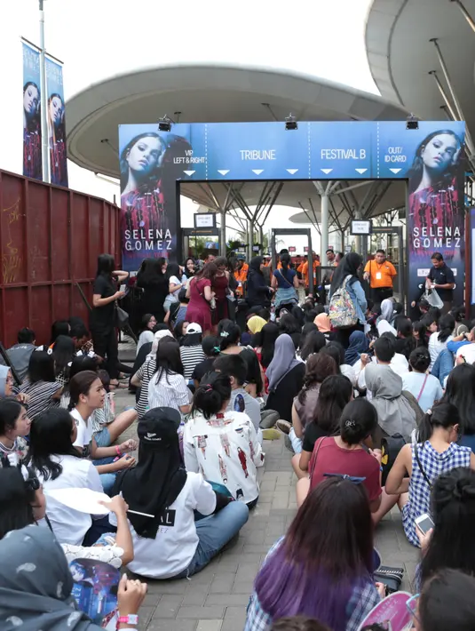 Para Selenator rela datang lebih awal agar mendapatkan tempat paling depan. Padahal, loket dibuka resmi jam 18.00. Seakan tidak memperdulikan panasnya matahari para Selenator menunggu didepan pintu masuk. (Adrian Putra/Bintang.com)