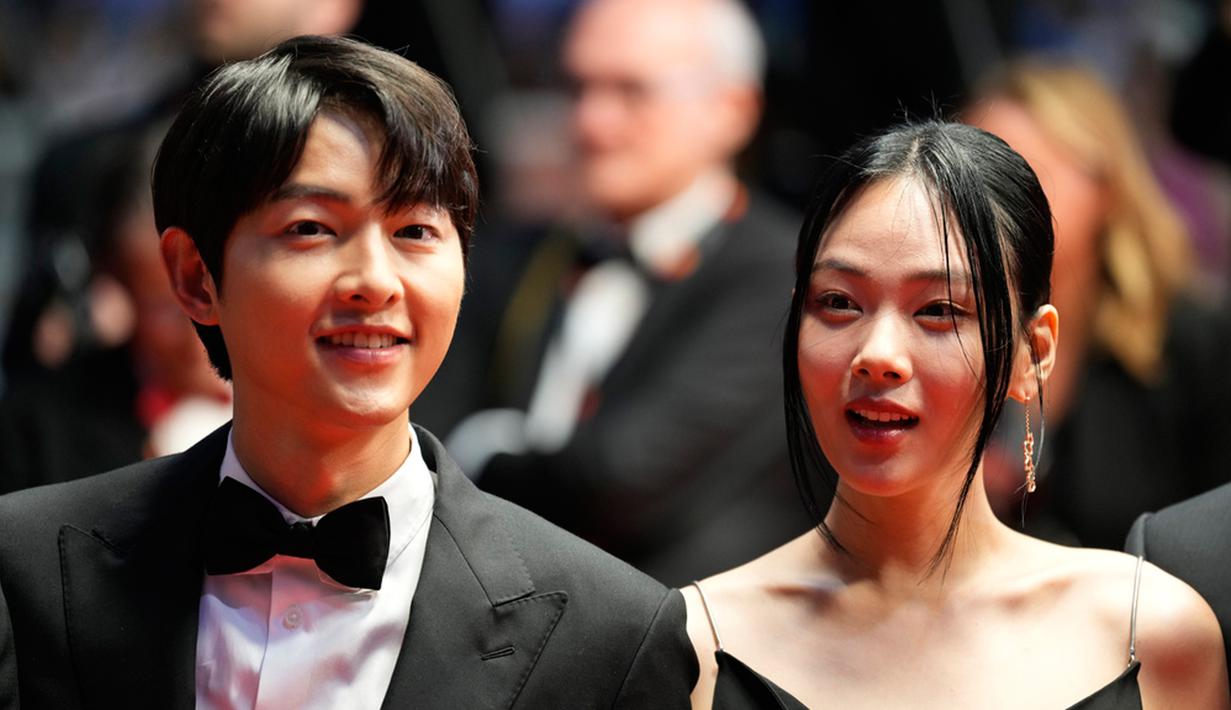 <p>Song Joong-ki (kiri) dan Kim Hyoung-seo berpose untuk fotografer setibanya pada pemutaran perdana film 'A Brighter Tomorrow' di Festival Film Cannes 2023, Prancis, Rabu (24/5/2023). (Photo by Scott Garfitt/Invision/AP)</p>