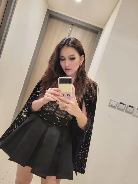 Sentuhan rok plisket mini dan belt, membuat gayanya semakin enerjik. [Foto: Instagram/ Ayu Ting Ting]