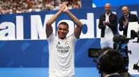 Penyerang Prancis Kylian Mbappe menyapa para penggemar saat penampilan pertamanya sebagai pemain Real Madrid di Estadio Santiago Bernabeu, Selasa (16/7/2024). (Pierre-Philippe MARCOU / AFP)