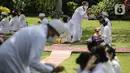 Umat Hindu menerima air suci saat upacara Tawur Agung Kesanga di Pura Amerta Jati, Cinere, Depok, Rabu (2/3/2022).  Upacara Tawur Agung Kesanga tersebut tahun ini hanya diikuti pemuka umat Hindu dan perwakilan dari pura sekitar dengan jumlah terbatas. (Liputan6.com/Faizal Fanani)