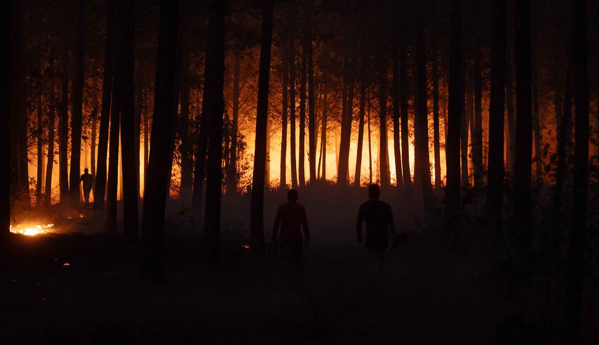 Sekitar 4.000 petugas pemadam kebakaran dikerahkan untuk mengendalikan api yang masih berkobar di tengah musim panas belahan bumi selatan. Tampak dalam foto, warga bergotong royong memadamkan vegetasi yang terbakar selama kebakaran hutan di kota Florida dekat kota Concepcion, Chile, pada Senin 19 Januari 2026. (Raul BRAVO/AFP)