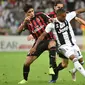 Pemain Juventus, Douglas Costa (kanan) berebut bola dengan pemain AC Milan, Lucas Paqueta (kiri) pada laga final di King Abdullah Sports City, Kamis (17/1). Juventus keluar sebagai kampiun dengan meraih kemenangan tipis 1-0. (Fayez Nureldine / AFP)