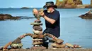 Harry Maddox dari Cornwall berkompetisi dalam Kejuaraan Menumpuk Batu Eropa 2019 di Dunbar, Skotlandia, Minggu (21/4). Pemenang dalam kejuaraan tersebut akan terbang ke llano Earth Art Festival dan mengikuti World Stone Balancing Competition 2020. (Andy Buchanan / AFP)