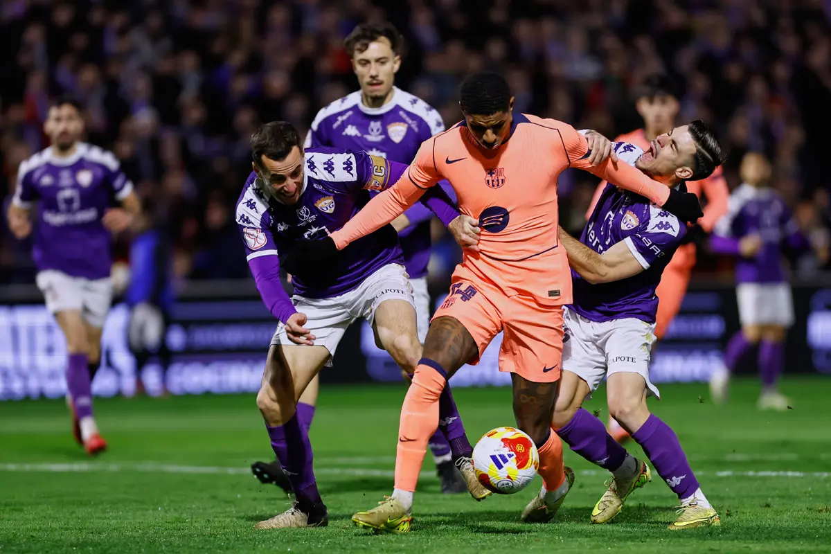 Bintang Barcelona Marcus Rashford dipepet pemain Guadalajara di babak 32 besar Copa del Rey di Estadio Pedro Escartin, Rabu (17/12/2025). (AP Photo/Rudy Garcia)