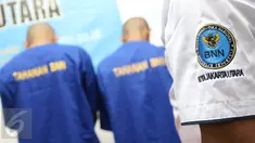 Petugas BNN menunjukkan dua tersangka berinisial H dan TS di kantor BNN Kota Jakarta Utara, Selasa (15/11). BNN Kota Jakarta Utara berhasil mengamankan barang bukti berupa sabu seberat 15,12 gram serta 50 butir ekstasi. (Liputan6.com/Immanuel Antonius)