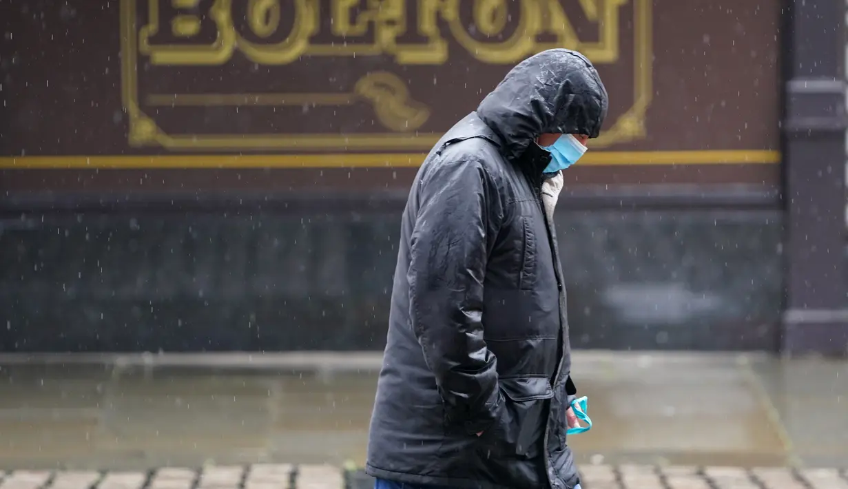 Seorang pria melintas di sebuah jalan di Bolton, Greater Manchester, Inggris (2/9/2020). Pembatasan di Bolton dan Trafford semula akan dilonggarkan semalam setelah sebelumnya mencatatkan penurunan kasus pada Agustus. (Xinhua/Jon Super)