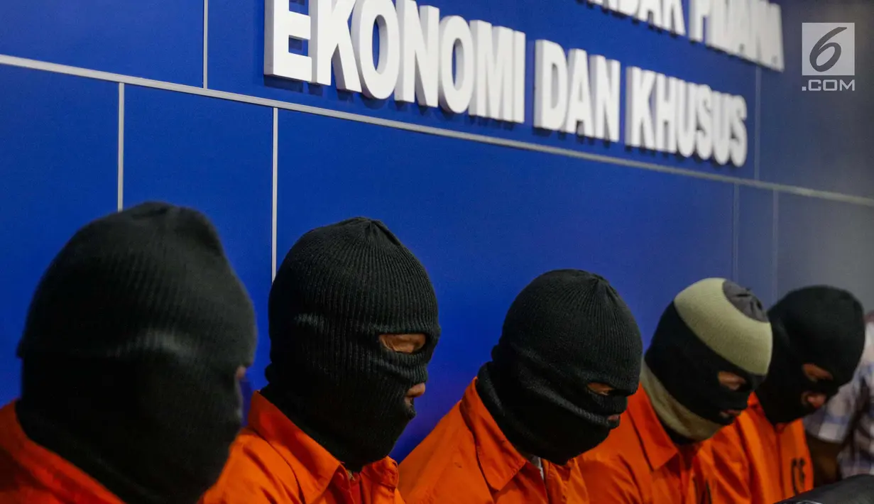 Tersangka ditunjukkan saat rilis uang palsu oleh Direktorat Tindak Pidana Ekonomi Khusus Bareskrim Polri, Jakarta, Kamis (7/11). Polisi mendapati barang bukti uang palsu pecahan Rp 100 ribu sebanyak 500 lembar siap edar. (Liputan6.com/Faizal Fanani)
