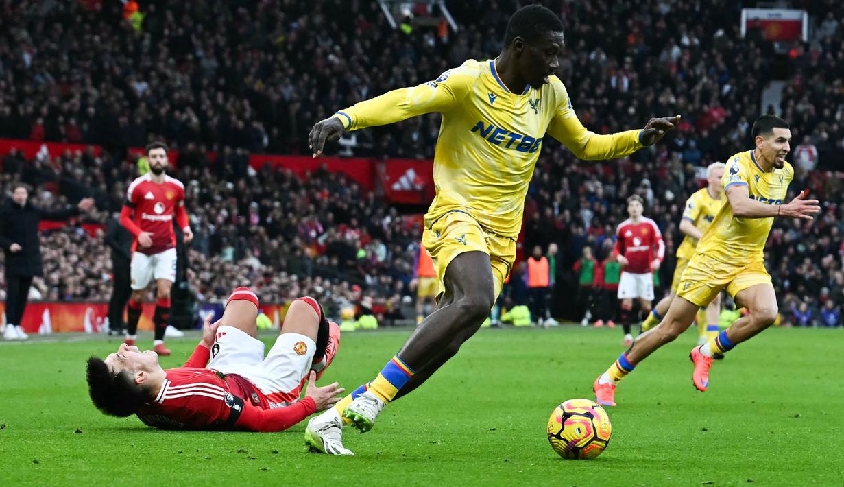 Pemain Manchester United, Lisandro Martinez (kiri) mengeram kesakitan setelah berebut bola dengan pemain Crystal Palace, Ismaila Sarr (kanan) dalam laga lanjutan Liga Inggris 2024/2025 di Old Trafford, Manchester, Inggris, Minggu (02/02/2025). (AFP/Paul Ellis)