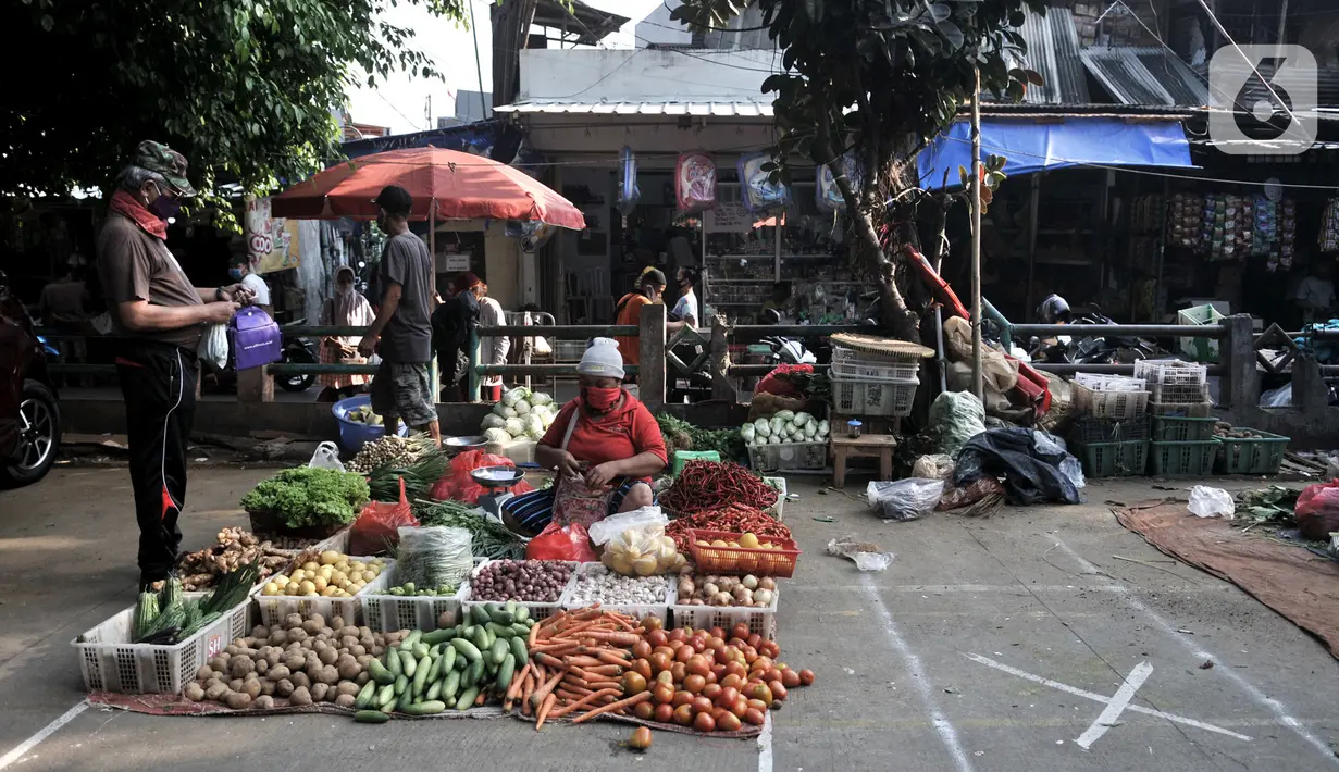 Pedagang berjualan dekat tanda ‘X‘ yang digunakan sebagai pembatas physical distancing di Pasar Perumnas Klender, Jakarta, Kamis (18/6/2020). Selain sistem ganjil genap kios, pengelola pasar menerapkan physical distancing antarlapak untuk mencegah penularan COVID-19. (merdeka.com/Iqbal S. Nugroho)