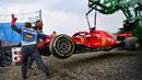 Petugas mengangkat mobil pebalap Jerman, Sebastian Vettel menggunakan traktor saat balapan F1 Grand Prix di Hockenheim racing circuit, Jerman, (22/7/2018). Vettel kehilangan kendali saat perubahan cuaca dan menabrak pembatas. (AFP/Andrej Isakovic)