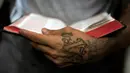 Mantan anggota dua geng sadis memegang Alkitab di Penjara San Francisco Gotera, El Salvador, 16 Juli 2018. (Oscar Rivera/AFP)