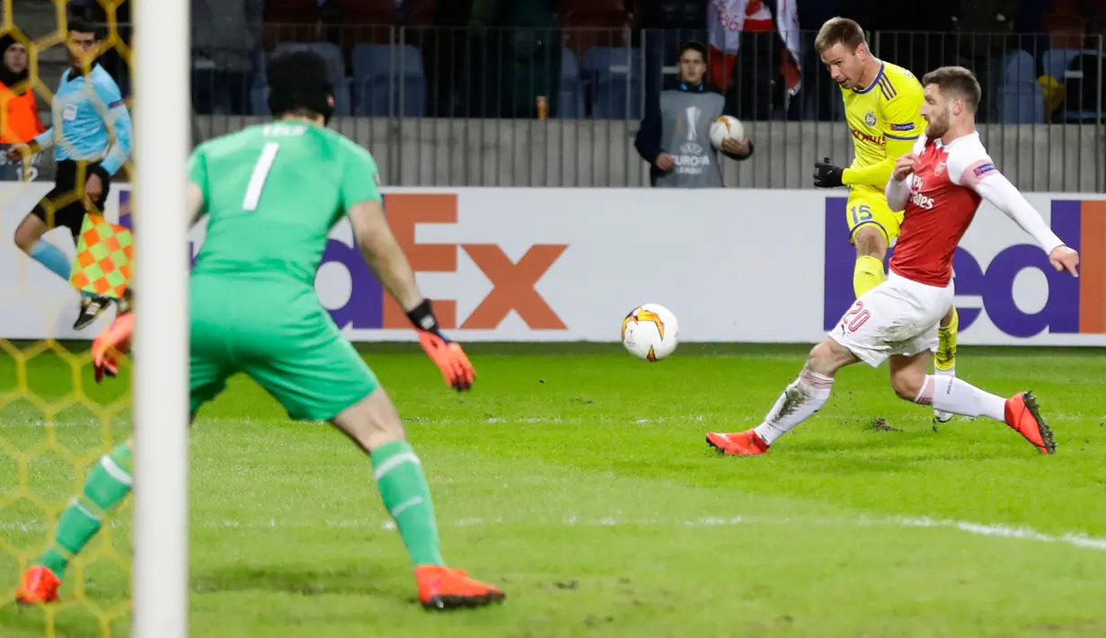 Pemain Arsenal Shkodran Mustafi mencoba menghalau bola tendangan dari pemain BATE Borisov, Maksim Skavysh pada leg pertama 32 besar Liga Europa di Borisov Arena, Kamis (14/2). Arsenal kalah 0-1 saat bertandang ke markas Bate Borisov. (AP/Sergei Grits)