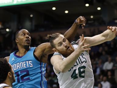 Pemain Charlotte Hornet, Dwight Howard (12) berebut bola dengan pemain Boston Celtics, Aron Baynes (46) pada laga NBA basketball game di TD Garden, Boston, (10/11/2017) waktu setempat. Boston Celtics menang 90-87. (AP/Michael Dwyer)