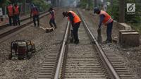 Petugas melakukan perawatan jalur rel kereta api di Buaran Pondok Kopi, Jakarta, Kamis (13/9). Perawatan dilakukan untuk menjamin keselamatan perjalanan kereta dan mencegah terjadi amblesnya bantalan rel. merdeka.com/imam buhori