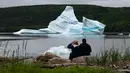 Wisatawan menyaksikan pemandangan gunung es terapung dekat King's Point, Newfoundland, Kanada, 3 Juli 2019. Gunung es terapung memberi pemandangan kontras yang unik, terutama bagi penggemar fotografi. (Johannes Eisele/AFP)