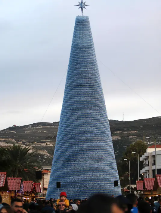 Sebuah Pohon Natal raksasa yang terbuat dari botol plastik di kota Chekka, Lebanon, 15 Desember 2019. Sebelumnya, botol-botol plastik tersebut dikumpulkan selama sekitar delapan bulan lewat bantuan jejaring media sosial. (Ibrahim CHALHOUB/AFP)