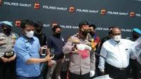 Kapolres Garut AKBP Wirdhanto Hadicaksono menunjukan senjata tajam jenis golok yang digunakan Hendi (38), pelaku pembunuhan berencana di Kecamatan Mekarmukti, Garut bagian selatan, kemarin. (Liputan6.com/Jayadi Supriadin)