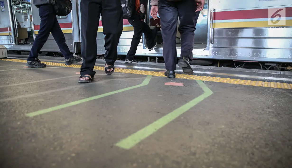 Garis antrean penumpang di Stasiun Juanda, Jakarta, Kamis (10/8). Uji coba garis antrean penumpang juga guna mengurangi bahaya kecelakaan seperti penumpang terjatuh dan terdorong saat keluar masuk KRL. (Liputan6.com/Faizal Fanani)