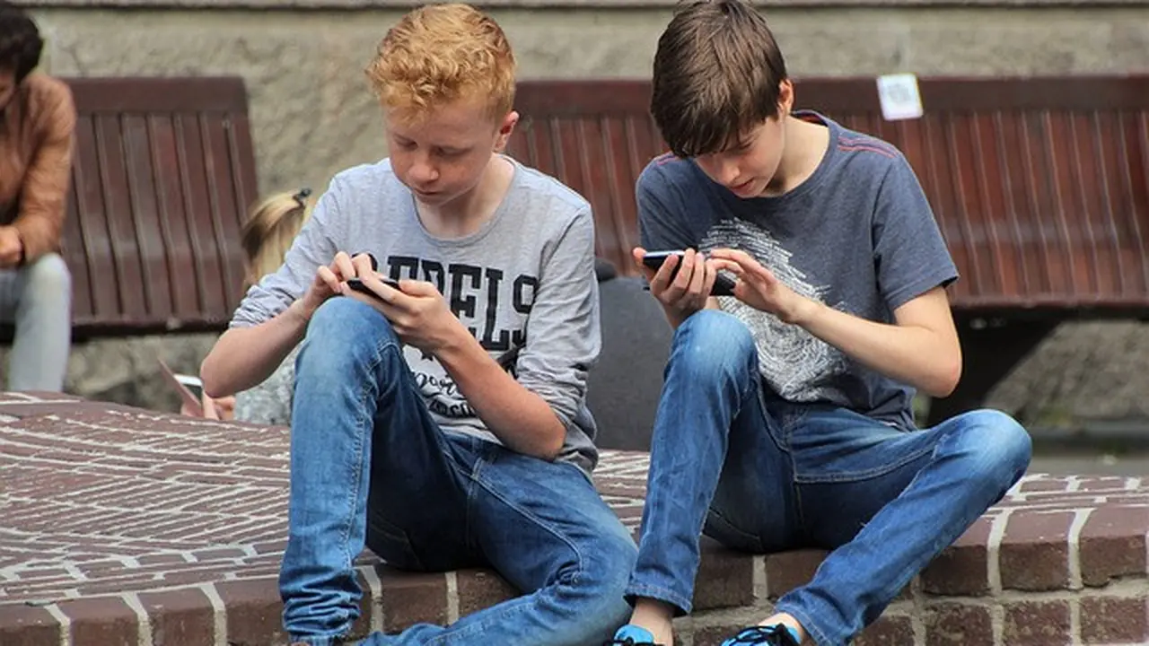 ilustrasi anak-anak sedang bermain handphone.