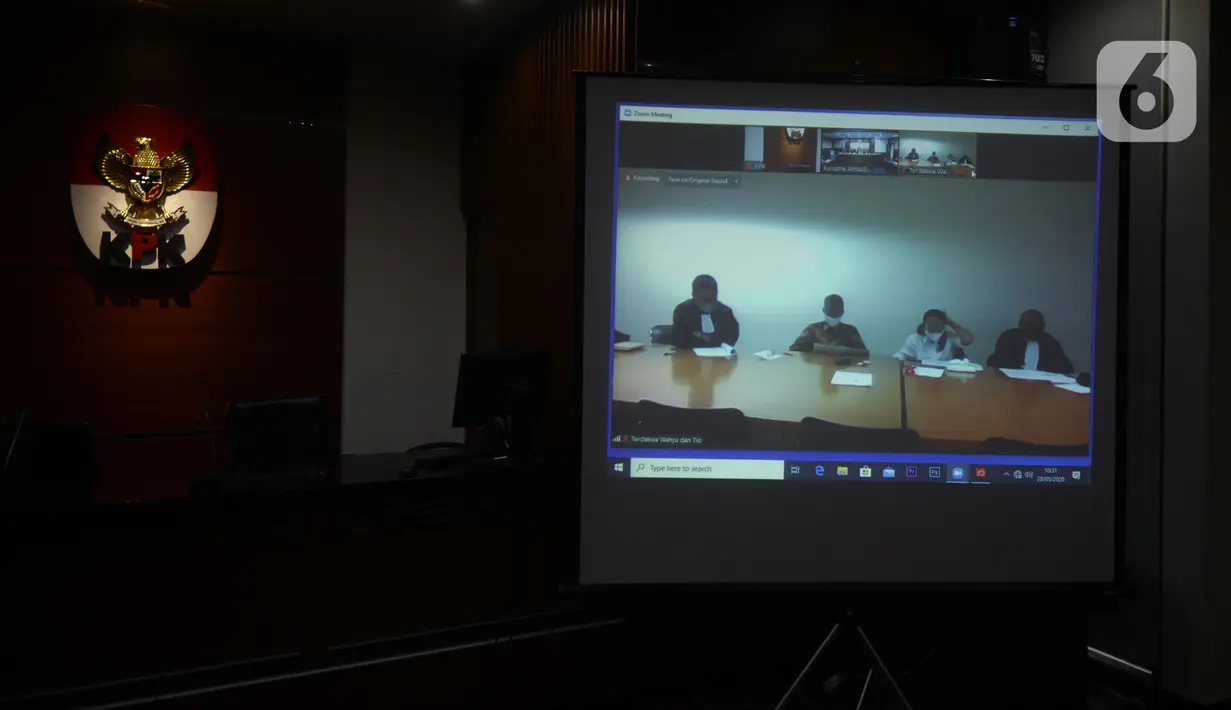 Mantan Komisioner KPU Wahyu Setiawan (kedua kiri) mendengarkan Jaksa Penutut Umum membacakan dakwaan saat sidang secara daring di Gedung KPK, Jakarta, Kamis (28/5/2020). Wahyu menjalani sidang dakwaan terkait kasus dugaan menerima suap pengurusan PAW anggota DPR dari PDIP. (merdeka.com/Dwi Narwoko)