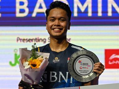 Menjadi satu-satunya wakil Indonesia tersisa mulai babak semifinal, Anthony Sinisuka Ginting sukses menuntaskan ajang kejuaraan bulu tangkis Singapore Open 2023 dengan raihan gelar juara setelah mengalahkan tunggal putra Denmark, Anders Antonsen dengan dua game langsung 21-16, 21-13 pada laga final yang digelar di Singapore Indoor Stadium, Singapura, Minggu (11/6/2023) sore WIB. Kemenangan yang tergolong mudah ini sekaligus menjadi gelar ketiga di Singapore Open dan menjadi gelar back to back setelah tahun lalu pun Ginting menjadi yang terbaik. (AFP/Roslan Rahman)