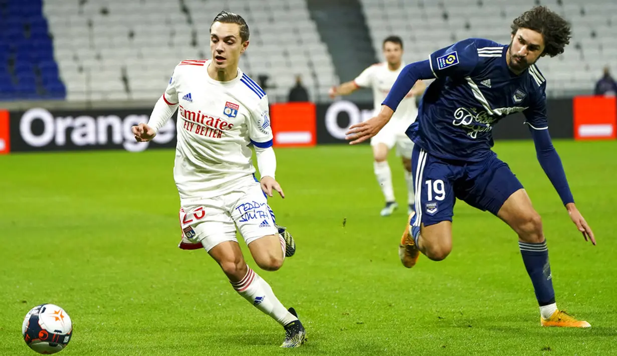 Pemain Lyon Maxence Caqueret (kiri) memperebutkan bola dengan pemain Bordeaux Yacine Adli pada pertandingan Liga Prancis di Lyon, Prancis, Jumat (29/1/2021). Lyon menang 2-1 atas Bordeaux dan naik ke puncak klasemen sementara Liga Prancis menyalip Paris Saint-Germain. (AP Photo/Laurent Cipriani)