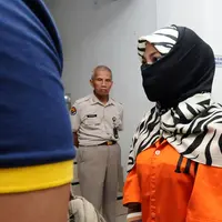 Salah satu tersangka kasus penyebaran ujaran bernada kebencian lewat internet digiring polisi usai rilis di Jakarta, Rabu (23/8). Tiga tersangka masuk dalam satu kelompok. (Liputan6.com/Helmi Fithriansyah)
