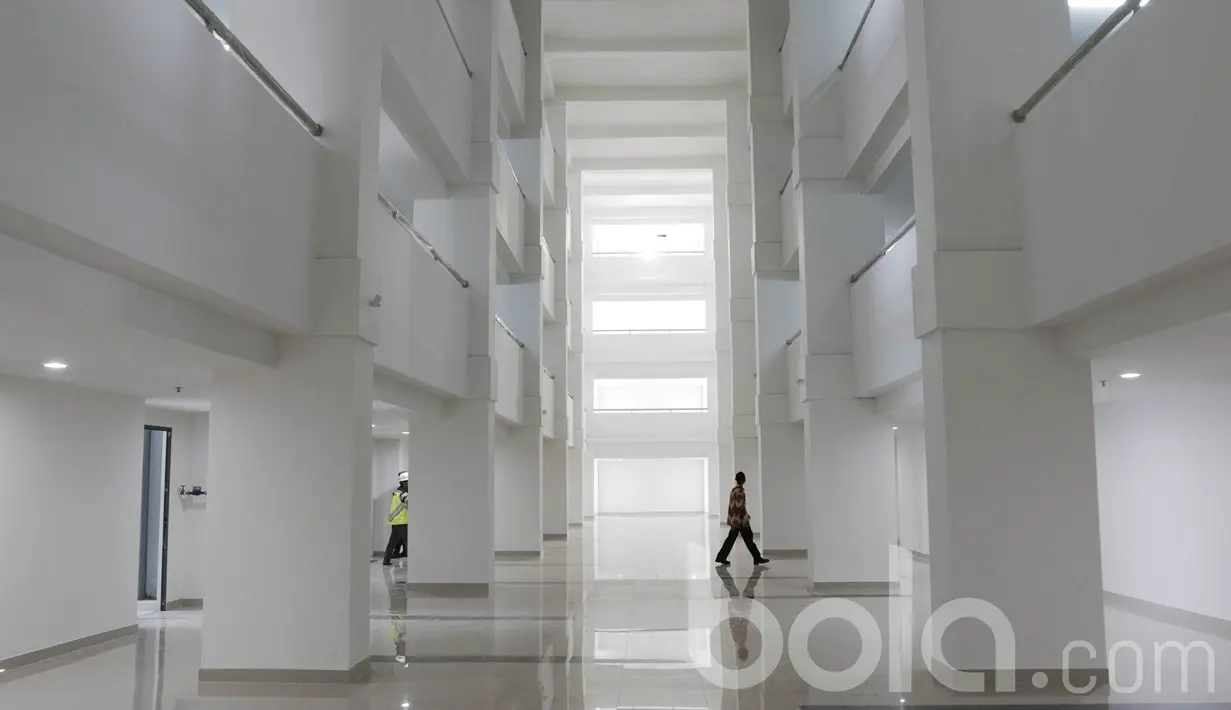 Seorang pekerja melintas di dalam pembangunan wisma Atlet di Kemayoran. Nilai kontrak pembangunan wisma Atlet Kemayoran ini mencapai Rp 3,4 triliun. (Bola.com/M Iqbal Ichsan)