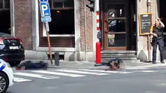 Seorang petugas polisi berdiri di lokasi dekat dua jenazah polisi korban penembakan di Liege, Belgia (29/5). Seorang pria menembak mati tiga orang di dekat sebuah kafe di Kota Liege, Belgia, Selasa waktu setempat. Dua di antara korban adalah polisi. (AP)