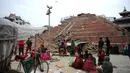 Sejumlah warga Nepal terlihat beristirahat di sekitar Kathmandu Durbar Square yang rusak parah, Minggu (26/4/2015). Gempa berkekuatan 7,8 Skala Richter itu dikabarkan telah menghancurkan ribuan rumah dan bangunan bersejarah (AFP Photo/Prakash Mathema)