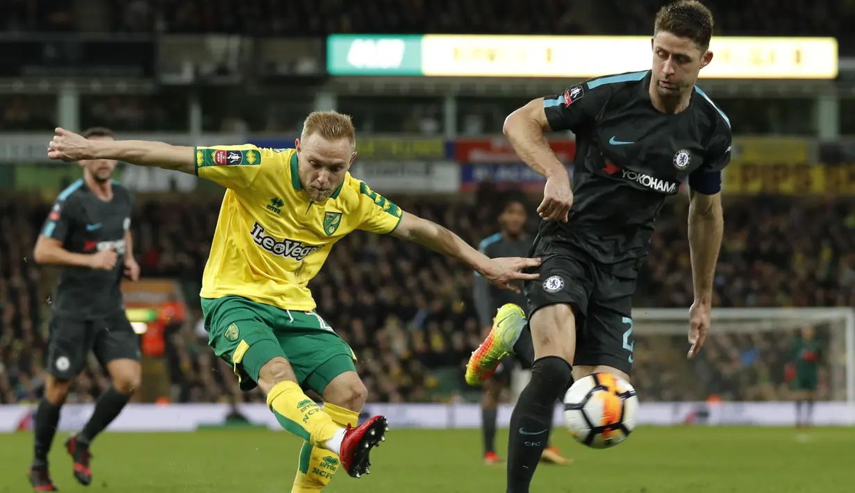 Pemain Norwich City, Alex Pritchard (kiri) melakukan tembakan saat diadang bek Chelsea, Gary Cahill pada laga Piala FA di Carrow Road, Norwich, (6/1/2018). Chelsea bermain imbang 0-0 dengan Norwich. (AFP/Adrian Dennis)