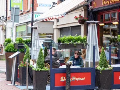 Sejumlah orang menyantap hidangan di luar bar yang kembali buka di Dublin, Irlandia, Senin (29/6/2020). Irlandia memasuki fase ketiga pencabutan pembatasan COVID-19, dengan mengizinkan lebih banyak bisnis kembali beroperasi dan memberikan kebebasan pergerakan lebih besar kepada masyarakat. (Xinhua)