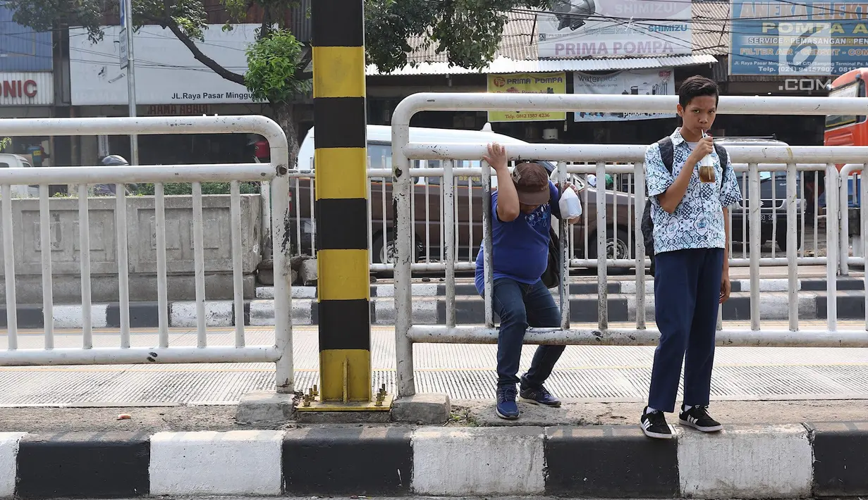 Warga memanfaatkan pagar pembatas jalan untuk menyeberang di kawasan Pasar Minggu, Jakarta, Kamis (5/4). Jembatan Penyeberangan Orang (JPO) yang tak kunjung diperbaiki membuat warga menyeberang lewat celah pagar pembatas. (Liputan6.com/Immanuel Antonius)